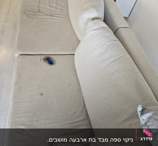 ספה עם כתמים כהים וכתם צבעוני על המושב